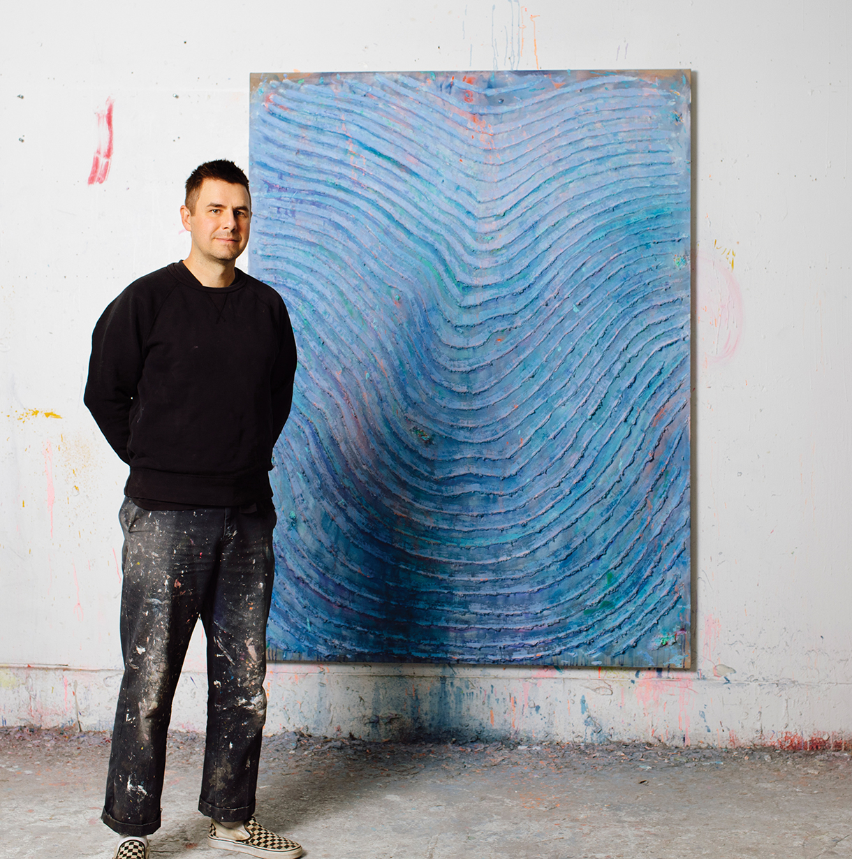 Andrew Dadson standing next to his Blue Wave artwork